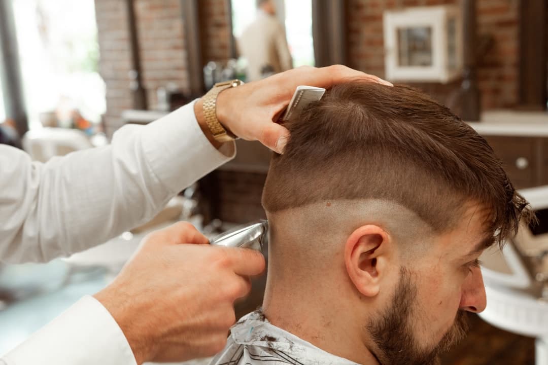 Barber cutting a client's hair at The Fade House
