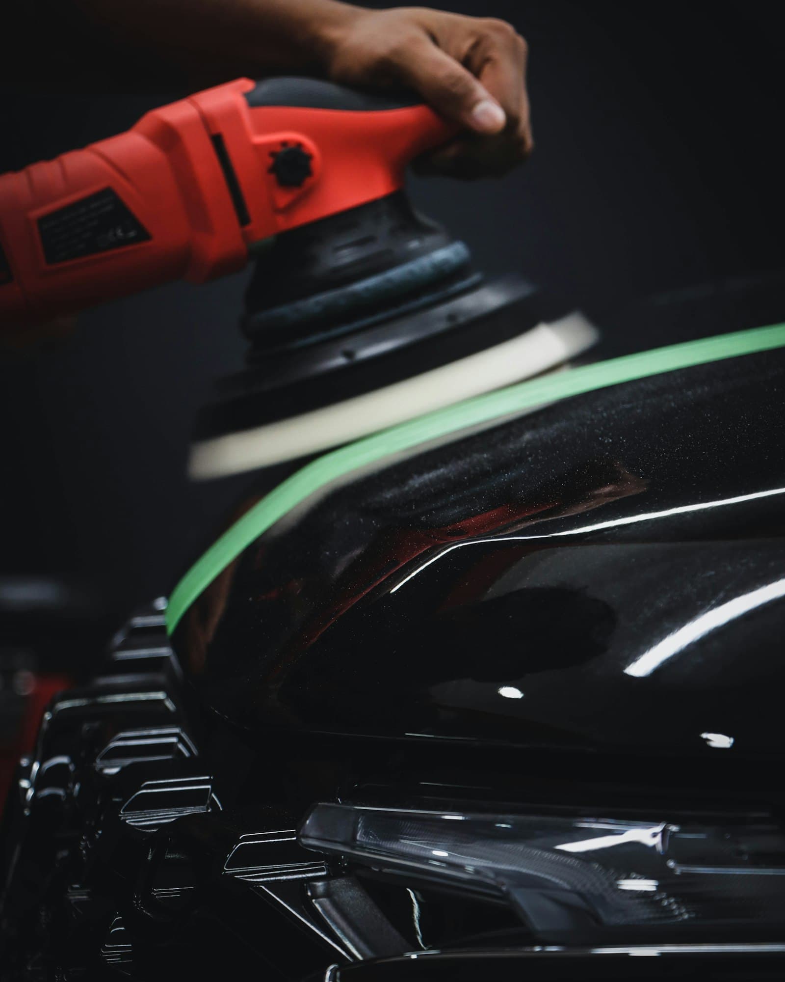 Detailer machine polishing a car panel in the Gloss & Grit studio